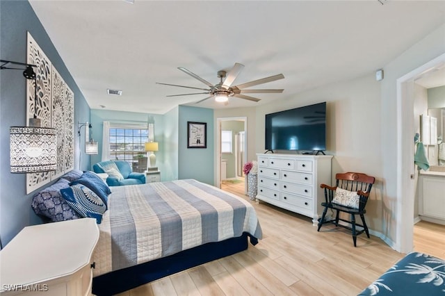 bedroom with light wood-type flooring, ceiling fan, and ensuite bathroom