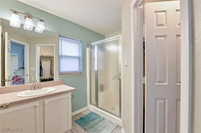 bathroom featuring vanity, a shower with shower door, and tile patterned flooring