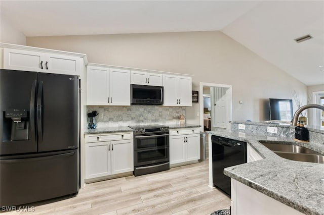 kitchen featuring sink, white cabinetry, tasteful backsplash, black appliances, and light stone countertops