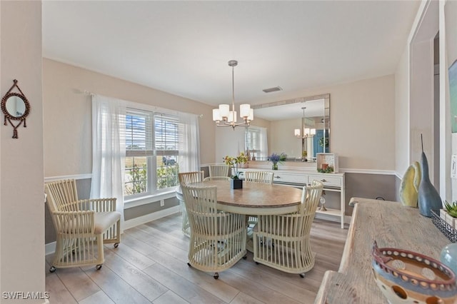 dining space featuring a notable chandelier and light wood-type flooring