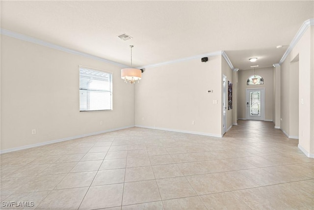 tiled spare room with crown molding and a chandelier