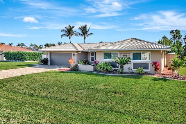 single story home featuring a garage and a front lawn