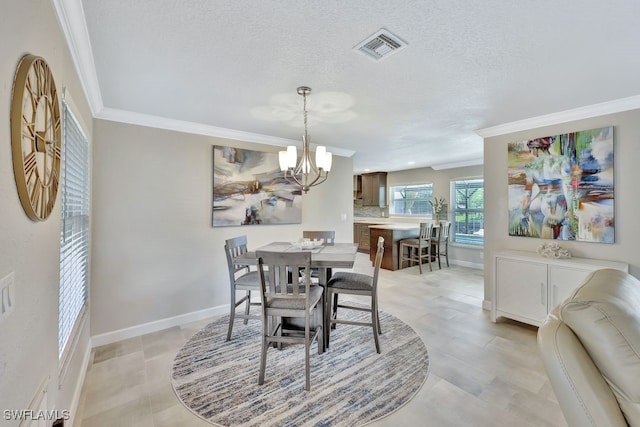 dining room with ornamental molding, a chandelier, and a textured ceiling