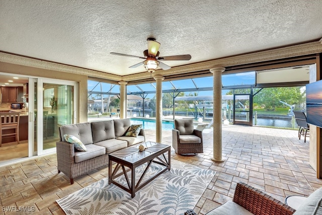 sunroom featuring a water view, a healthy amount of sunlight, and ceiling fan