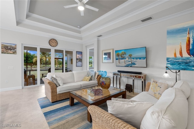 living area featuring ornamental molding, a tray ceiling, and visible vents