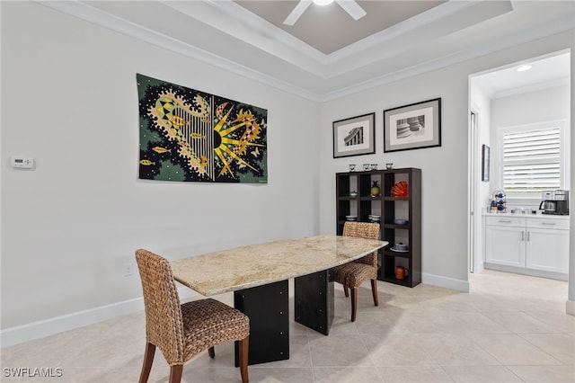 dining room featuring baseboards, a raised ceiling, ceiling fan, crown molding, and light tile patterned flooring