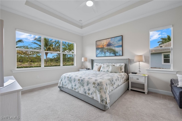 carpeted bedroom featuring ceiling fan, a raised ceiling, and baseboards