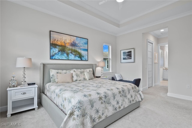 bedroom featuring a raised ceiling, ornamental molding, carpet flooring, and baseboards