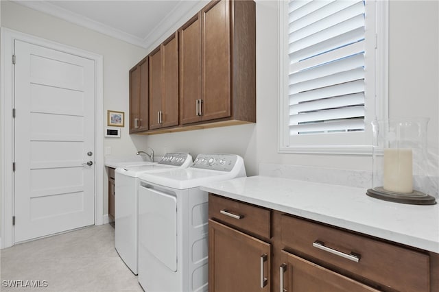 washroom with washing machine and dryer, cabinet space, and crown molding