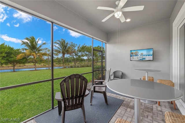 sunroom / solarium featuring a ceiling fan