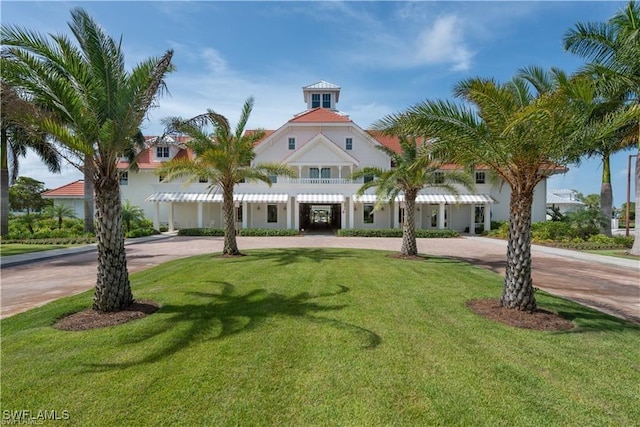 mediterranean / spanish house featuring curved driveway and a front lawn