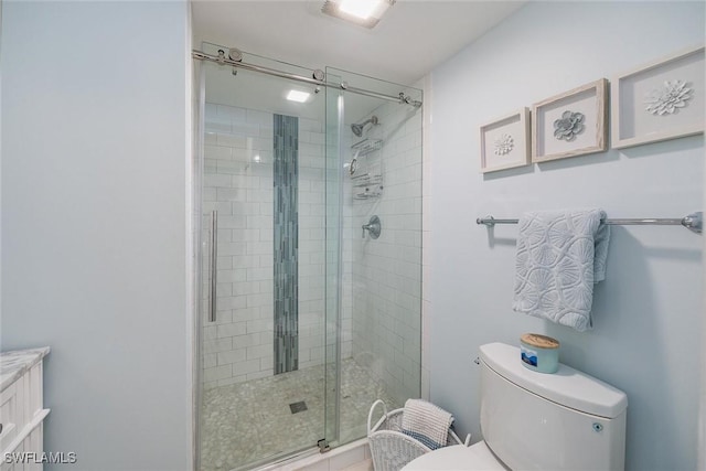 bathroom with an enclosed shower, vanity, and toilet