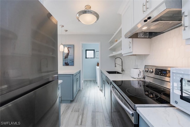 kitchen featuring sink, stainless steel range with electric stovetop, refrigerator, pendant lighting, and white cabinets