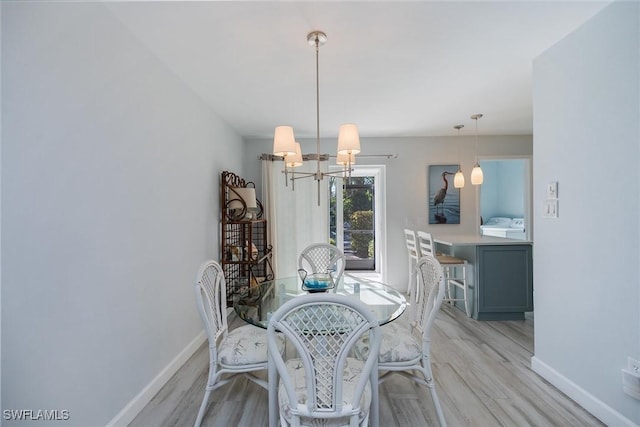 dining room featuring a notable chandelier and light wood-type flooring