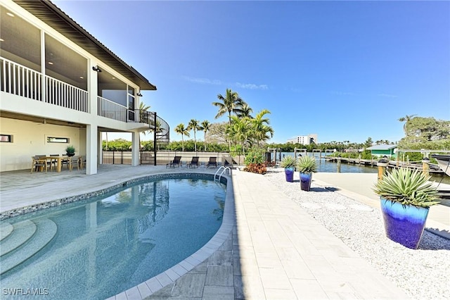 view of swimming pool with a water view and a patio