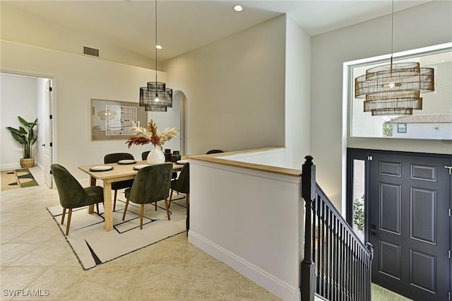 tiled dining room featuring vaulted ceiling