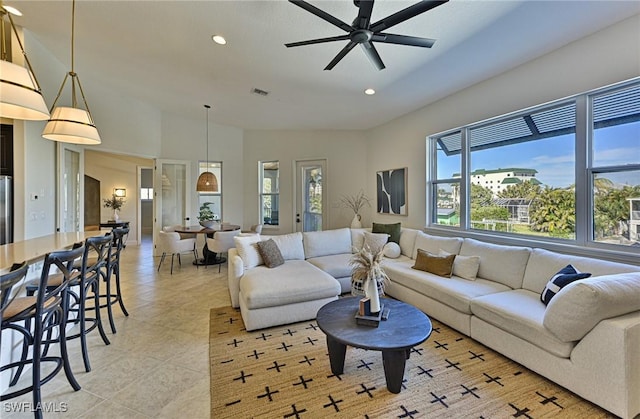 living room featuring ceiling fan, vaulted ceiling, and light tile patterned floors