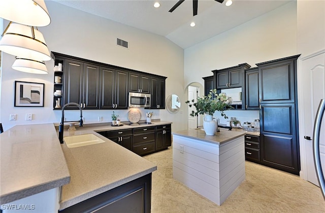 kitchen featuring sink, decorative light fixtures, high vaulted ceiling, black electric cooktop, and ceiling fan