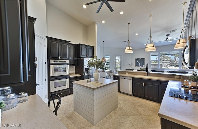 kitchen featuring pendant lighting, an island with sink, stainless steel appliances, and sink