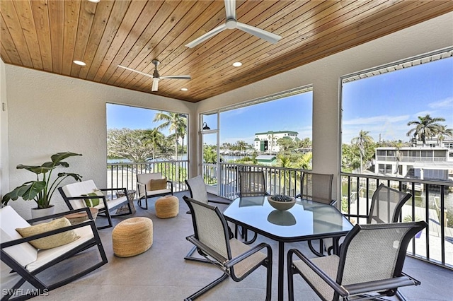 sunroom featuring a water view, wooden ceiling, and ceiling fan