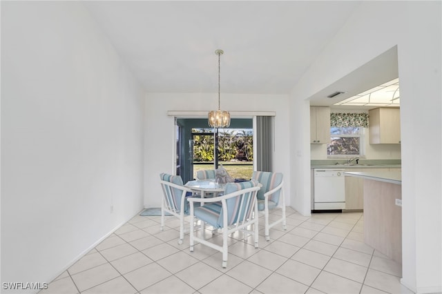 tiled dining room with sink, a wealth of natural light, and a chandelier