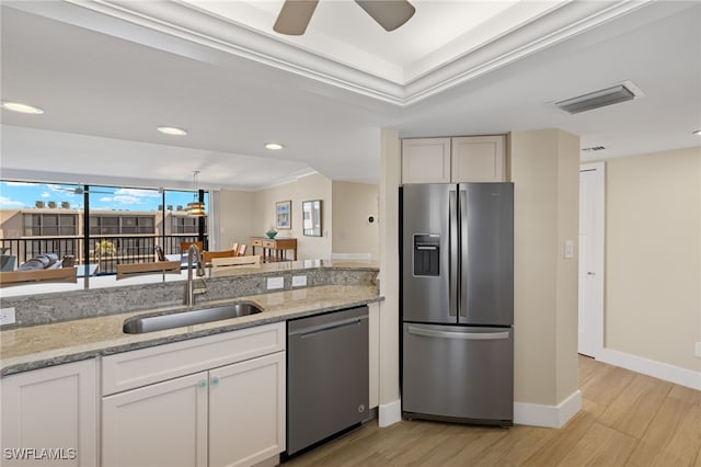 kitchen featuring appliances with stainless steel finishes, sink, white cabinets, and light stone counters