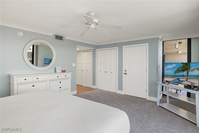 bedroom with multiple closets, crown molding, light carpet, and ceiling fan