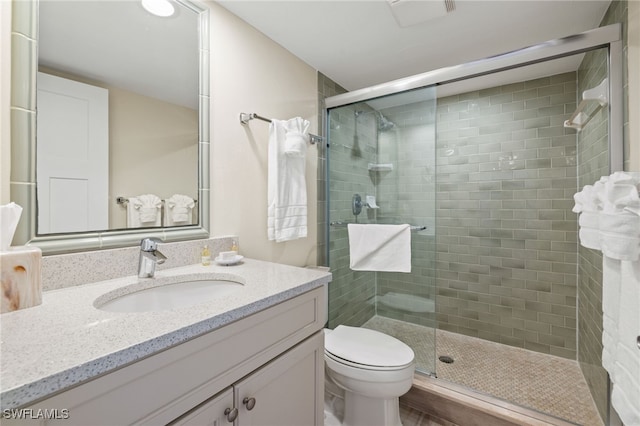 bathroom featuring vanity, toilet, and walk in shower