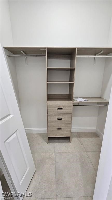 walk in closet with light tile patterned floors