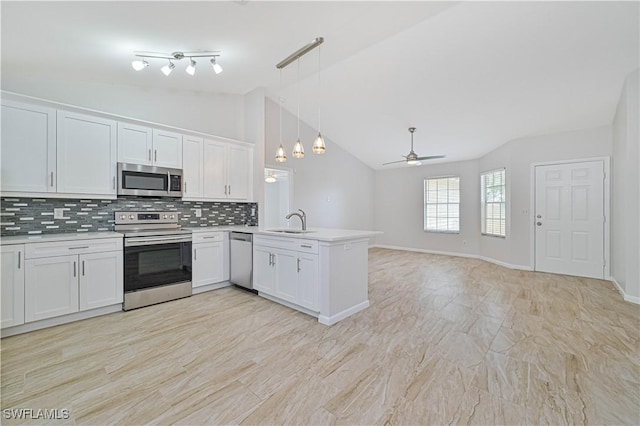 kitchen featuring stainless steel appliances, hanging light fixtures, white cabinets, and kitchen peninsula