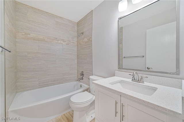 full bathroom with tiled shower / bath, vanity, and toilet