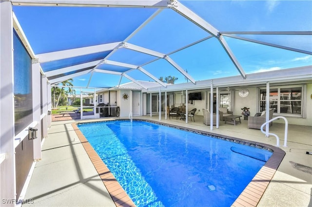 view of pool featuring a patio, an outdoor hangout area, and glass enclosure