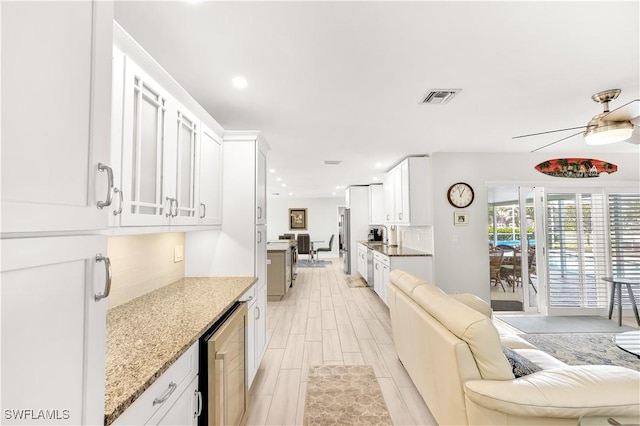 kitchen with tasteful backsplash, white cabinetry, and light stone counters