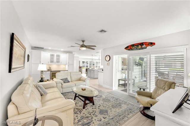 living room featuring ceiling fan and light hardwood / wood-style floors