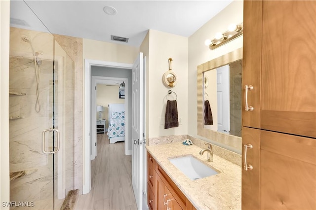 bathroom with vanity, a shower with door, and wood-type flooring