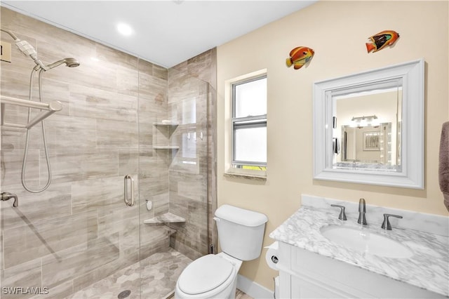 bathroom with vanity, a shower with shower door, and toilet