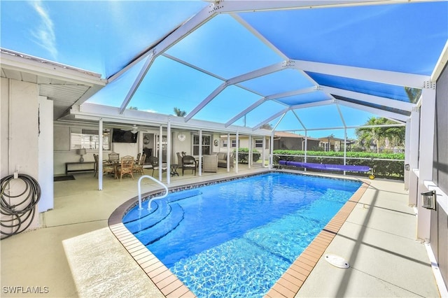 view of pool featuring outdoor lounge area, a patio area, and glass enclosure