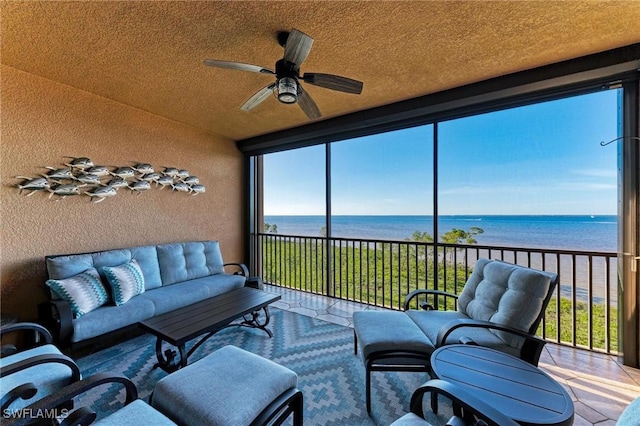 sunroom / solarium with a water view and ceiling fan