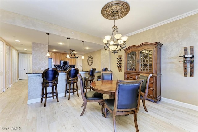 dining area featuring an inviting chandelier, ornamental molding, and light hardwood / wood-style floors