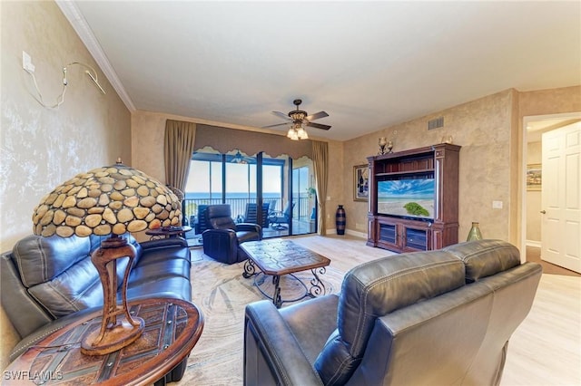 living room featuring crown molding, ceiling fan, and light hardwood / wood-style floors