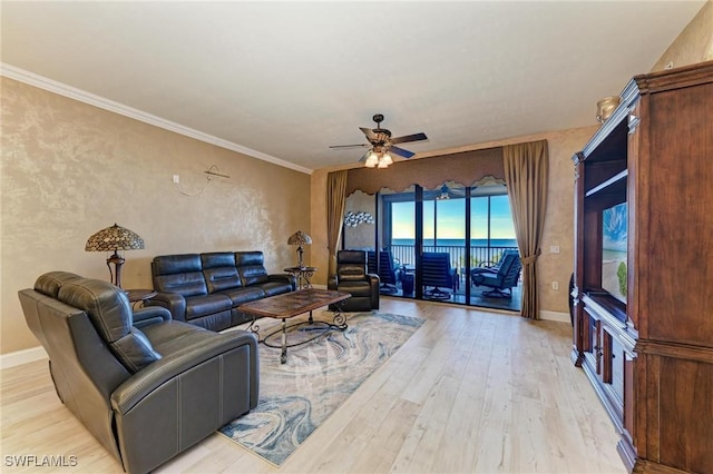 living room featuring crown molding, ceiling fan, and light wood-type flooring