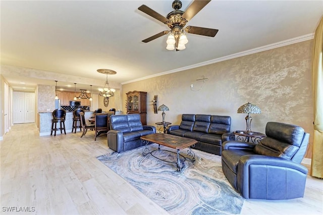 living room with hardwood / wood-style flooring, crown molding, and ceiling fan with notable chandelier