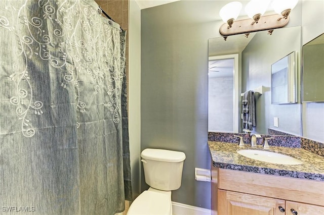 bathroom featuring vanity, curtained shower, and toilet