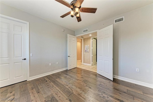 unfurnished bedroom featuring ceiling fan and dark hardwood / wood-style flooring