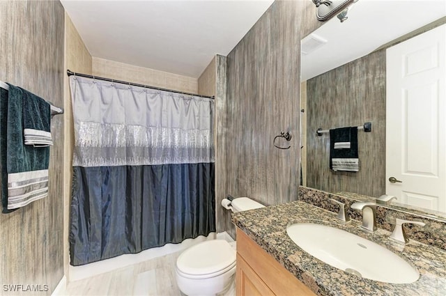 bathroom featuring vanity, curtained shower, and toilet