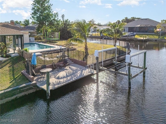 dock area with a water view, a lawn, and a patio area