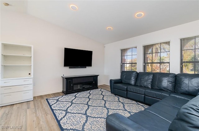 living room featuring lofted ceiling and light hardwood / wood-style flooring