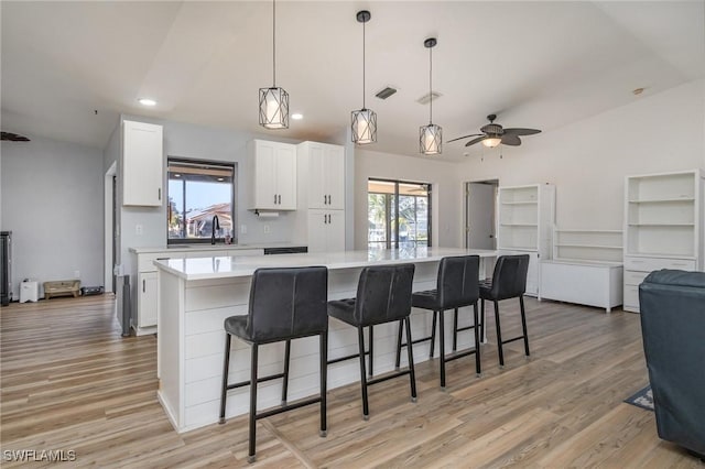 kitchen with hanging light fixtures, white cabinetry, and a large island