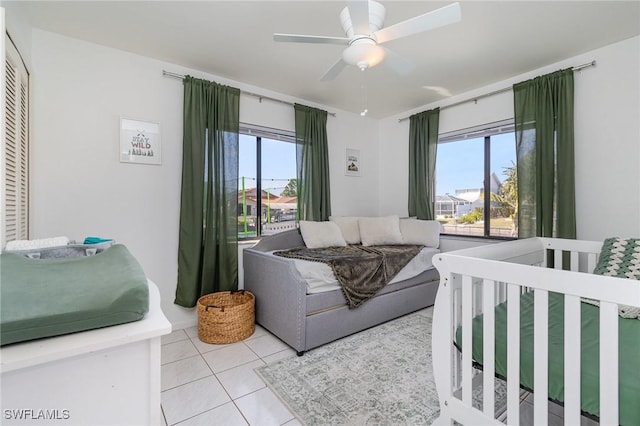 tiled bedroom featuring ceiling fan