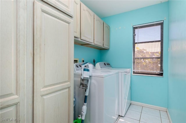 washroom with independent washer and dryer, cabinets, and light tile patterned flooring